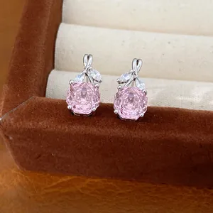 Macro view of pink flower-shaped zircon stud earrings displayed in a velvet jewelry box