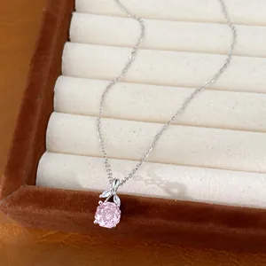 Close-up of elegant pink flower zircon pendant on silver clavicle chain in box