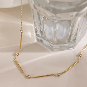 Close-up detail of a 18k gold plated geometric necklace with sparkling cubic zirconia