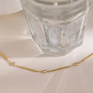 Detail of a minimalist 18k gold plated stainless steel necklace with CZ stones