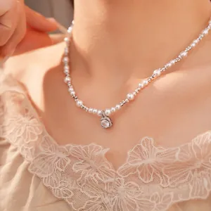 Close-up of elegant beaded pearl necklace with a sparkling square zircon pendant.