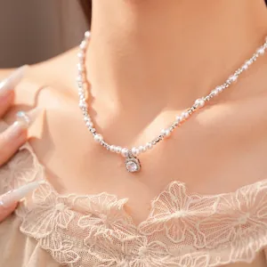 Close-up of elegant pearl beaded necklace with square zircon pendant on model