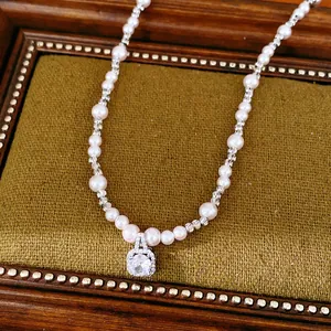 Close-up of elegant beaded zircon square pearl necklace on vintage velvet tray.