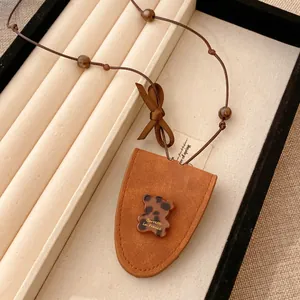Detailansicht des Bären-Anhängers an der braunen Leder-Brillenkette