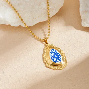 Gedetailleerde opname van een vintage vergulde ketting met een blauwe emaille hanger