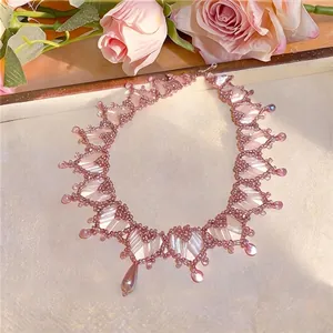 Elegante collar de cuentas rosa con gotas de perla en un refinado entorno de flores