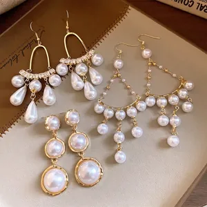 Eleganti orecchini di perle in stile francese con placcatura in oro su un diario vintage