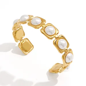 Bracelet jonc ouvert élégant en acier inoxydable doré avec perles blanches, vue à 45 degrés