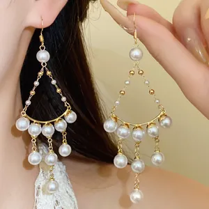 Detailed view of French luxury pearl tassel earrings with gold-tone hooks for women