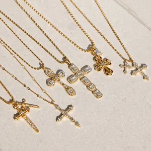 Detailansicht verschiedener luxuriöser goldener Kreuzanhänger aus Titanstahl mit Zirkonia.