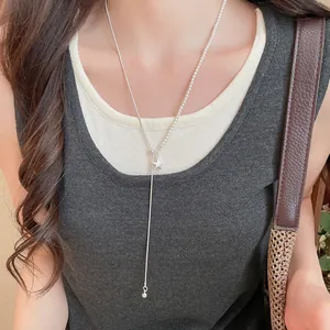 Gedetailleerd beeld van een asymmetrische zilveren sterhangerketting op een model