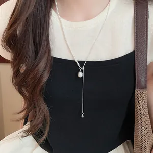 Detail van een minimalistische zilveren asymmetrische ketting met parel