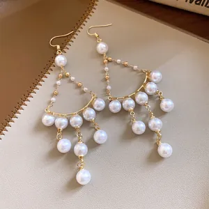 Elegant macro shot of French light luxury pearl fringe earrings with golden ear hooks