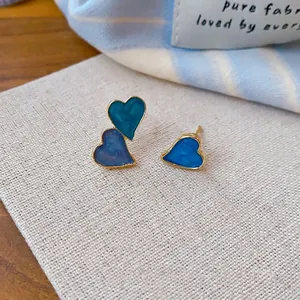 Boucles d'oreilles asymétriques en émail coeur bleu avec bords dorés au design pur