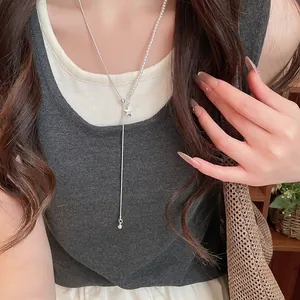 Detailopname van een elegante zilveren asymmetrische sterrenhanger ketting op model.