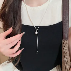 Elegante zilveren asymmetrische ketting met parelhanger op een stijlvol model