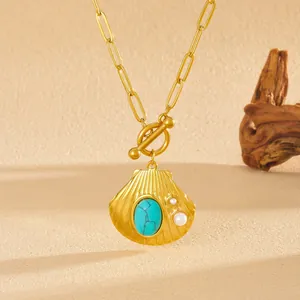 Gedetailleerde weergave van een vintage gouden schelpketting met turkoois en parels
