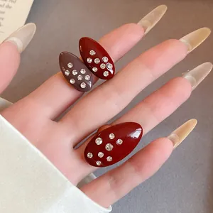 Macro view of vintage oval oil-dripping rings with inlaid rhinestones on a hand
