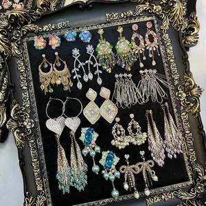 Elegant collection of vintage zircon tassel earrings and floral studs in ornate frame
