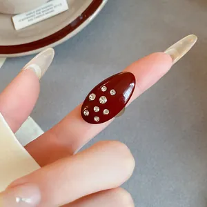 Close-up of a vintage burgundy enamel oval ring with sparkling rhinestone accents.
