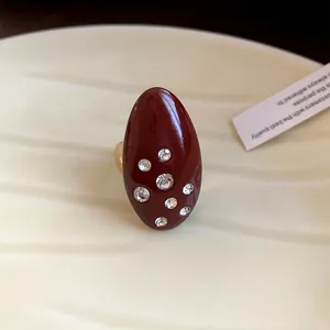 Macro close-up showing the detail of a vintage oval red enamel ring with inlaid rhinestones