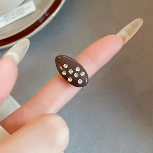 Detailed view of a vintage oval oil drip ring with sparkling rhinestone studs.