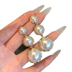 Elegant French style tiered round pearl drop earrings with polished gold-tone metal.
