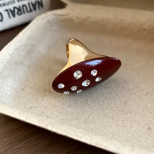 Detailed macro view of vintage gold ring with burgundy enamel and inlaid crystals.