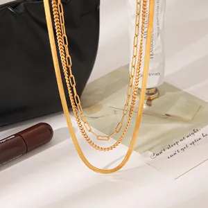 Nahaufnahme einer mehrlagigen 18 Karat Goldkette mit Büroklammer- und Schlangendesign