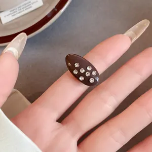 Macro view of a vintage oval dark brown enamel ring with sparkling rhinestones