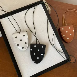 Nahaufnahme von drei stylischen Leder-Halsketten mit Brillenhalter und gepunktetem Muster