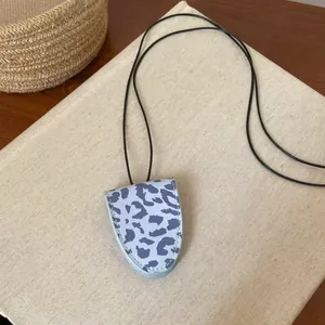 Detailansicht einer Brillenhalter-Halskette aus Leder mit Leopardenmuster in Blautönen.