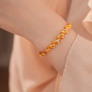 Detailansicht eines gebürsteten Gold-Herzarmbands mit funkelnden Zirkon-Akzenten