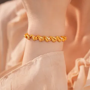 Elegante Detailansicht eines 24k vergoldeten Herzarmbands mit Zirkoniasteinen am Handgelenk
