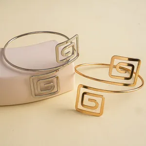 Détail de bracelets joncs creux géométriques minimalistes en finitions or et argent