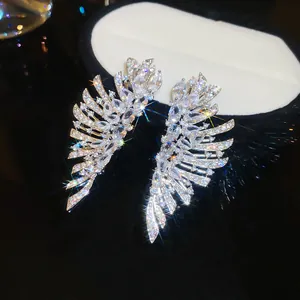 Vue détaillée de boucles d'oreilles ailes en zircone étincelantes pour soirées de luxe chic