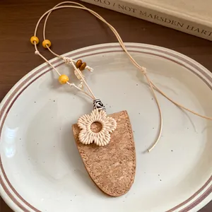 Gros plan d'un collier bohème en cuir et résine avec pendentif à texture de liège
