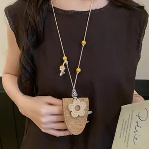 Vue détaillée d'un collier bohème artistique en cordon cuir avec fleur et liège