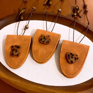 Gros plan de colliers pendentifs en cuir avec breloques chat, ours et cœur en résine léopard