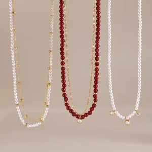 Detail view of natural stone necklaces with freshwater pearls and red agate beads.