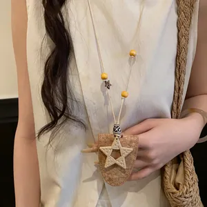 Gros plan d'un collier bohème avec pendentif étoile tissée et perles en bois sur un mannequin