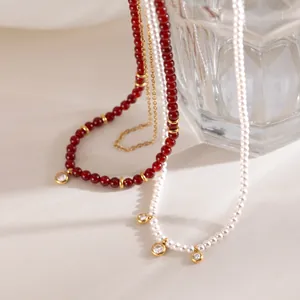 Detail view of red agate and white freshwater pearl necklaces with crystal charms