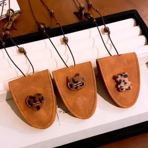 Vue détaillée de colliers porte-lunettes en cuir avec des breloques en résine chat.
