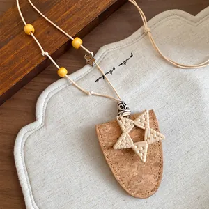 Détail d'un collier bohème étoile en liège et cuir avec pince à lunettes pour femme.