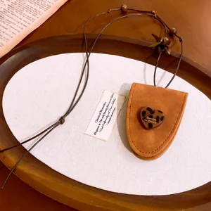Détail du collier pendentif cœur en cuir et résine avec motif léopard