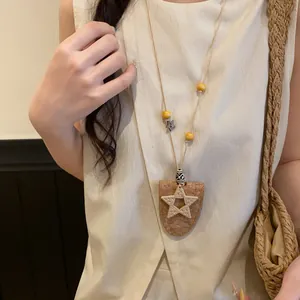 Gros plan détaillé d'un collier bohème avec étoile en liège et détails d'étoile tressée