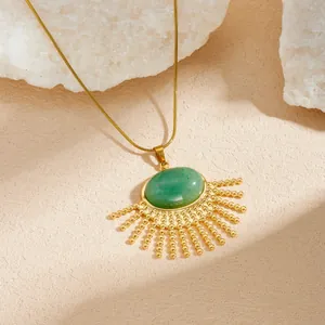 Detail van vintage waaiervormige ketting met groene ovale steen en gouden kralen