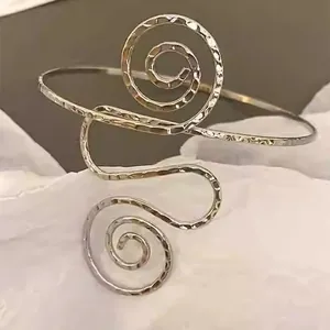 Detailansicht eines silbernen Armreifs mit gehämmertem Metall und Spiral-Design.
