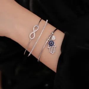 Nahaufnahme des dreiteiligen silbernen Zirkon-Armreif-Sets mit Hamsa-Hand-Anhängern