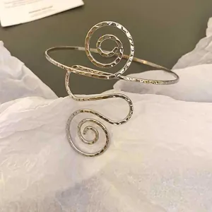 Detailansicht eines trendigen silbernen Spiralarmreifens mit Hammerschlag-Metalltextur